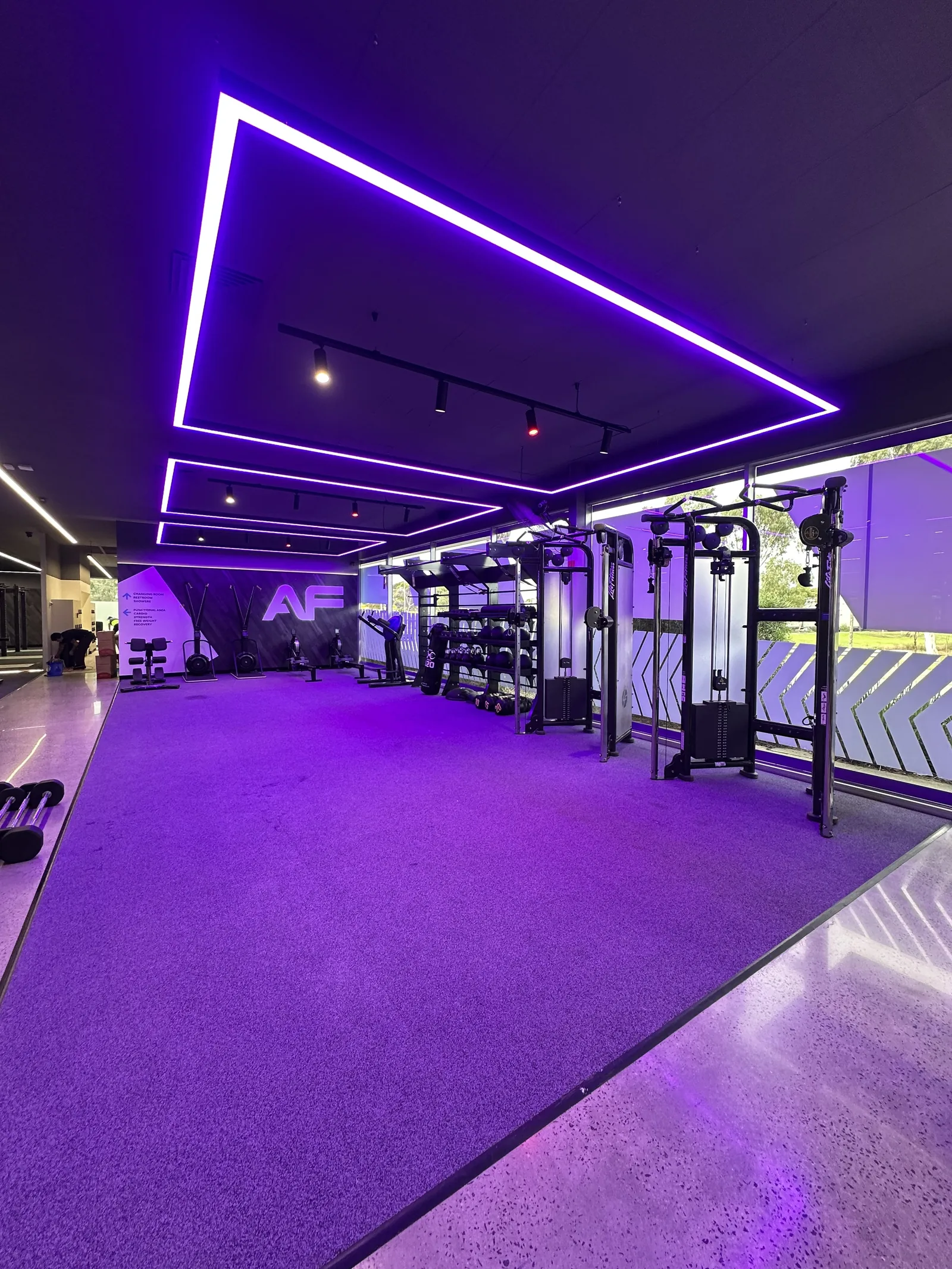 Group fitness studio with a seamless poured floor under coloured LED lighting